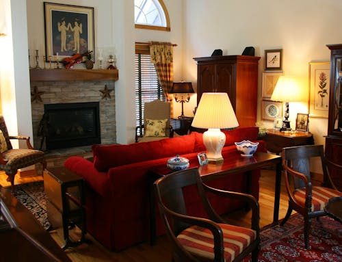 Brown Wooden Console Table Next to Red Loveseat