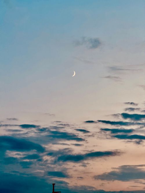 Free A tranquil evening sky with a crescent moon and scattered clouds, perfect for a peaceful mood. Stock Photo
