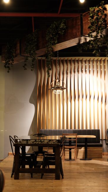 Fotomural Área de comedor elegante con decoración de madera, muebles modernos y luces ambientales.