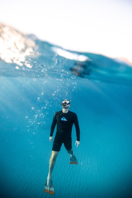 Free Split-Level Photography of Man Underwater Stock Photo