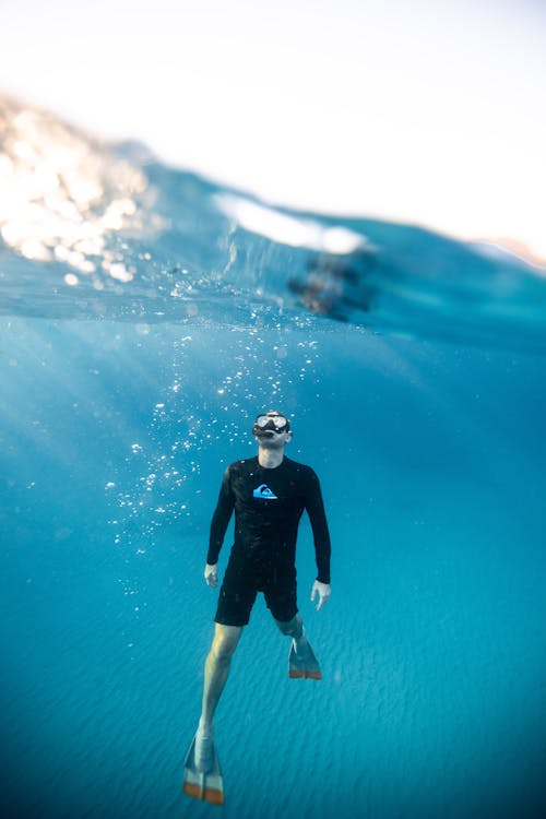 Fotografía De Dos Niveles Del Hombre Bajo El Agua