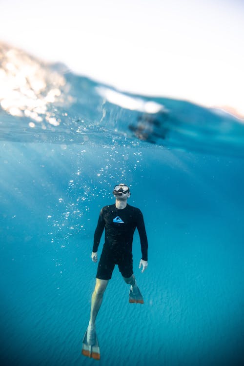 Split-Level Photography of Man Underwater