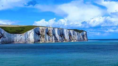 Free Breathtaking view of the White Cliffs of Dover against a vibrant blue sea and sky. Stock Photo