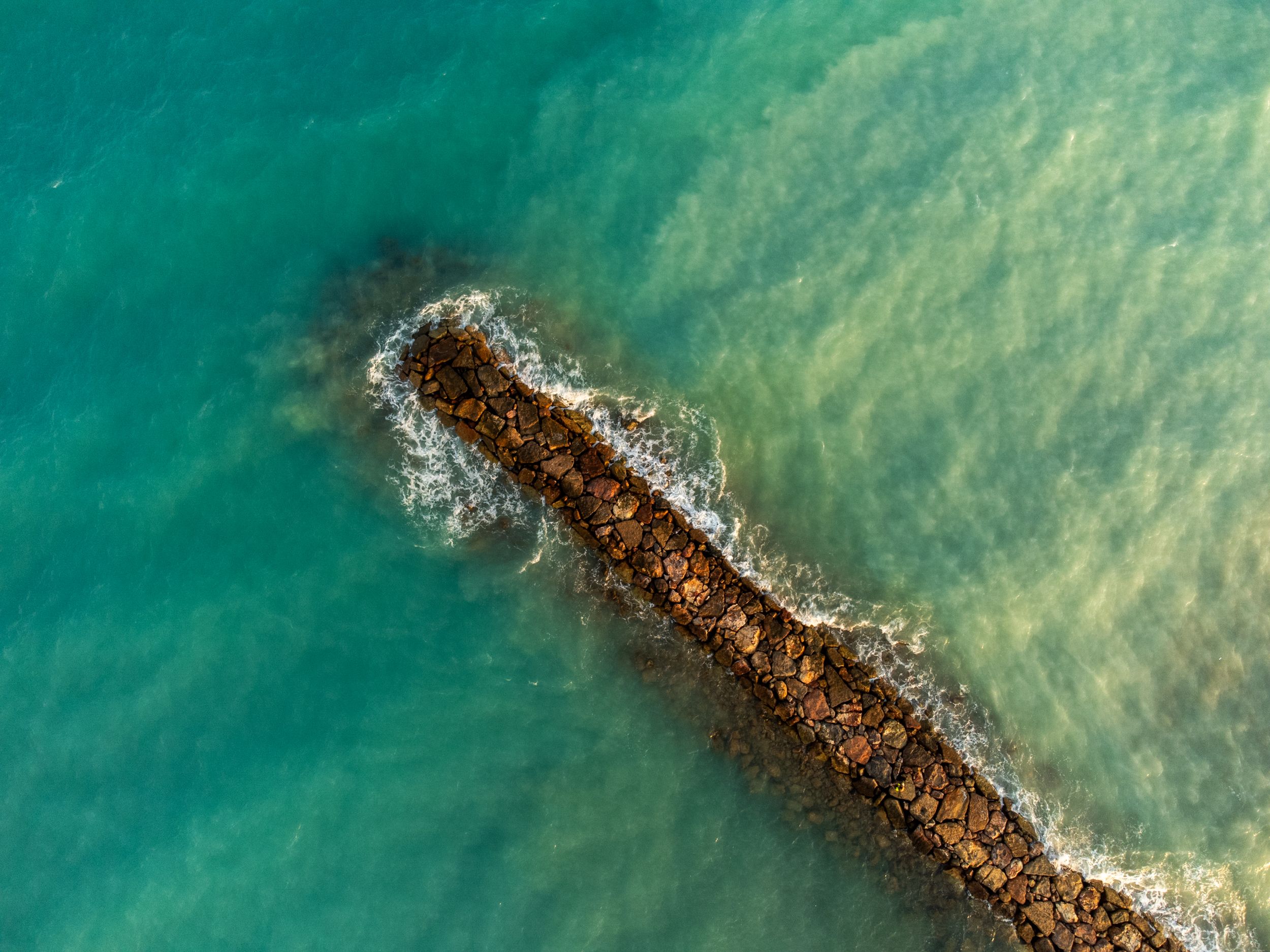 An aerial view of a small rock in the ocean · Free Stock Photo