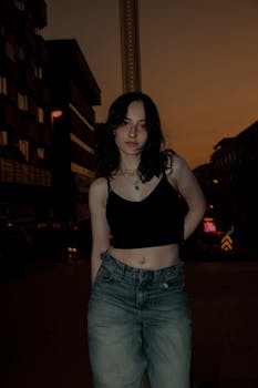 Portrait of a young woman in casual outfit on a city street at night.