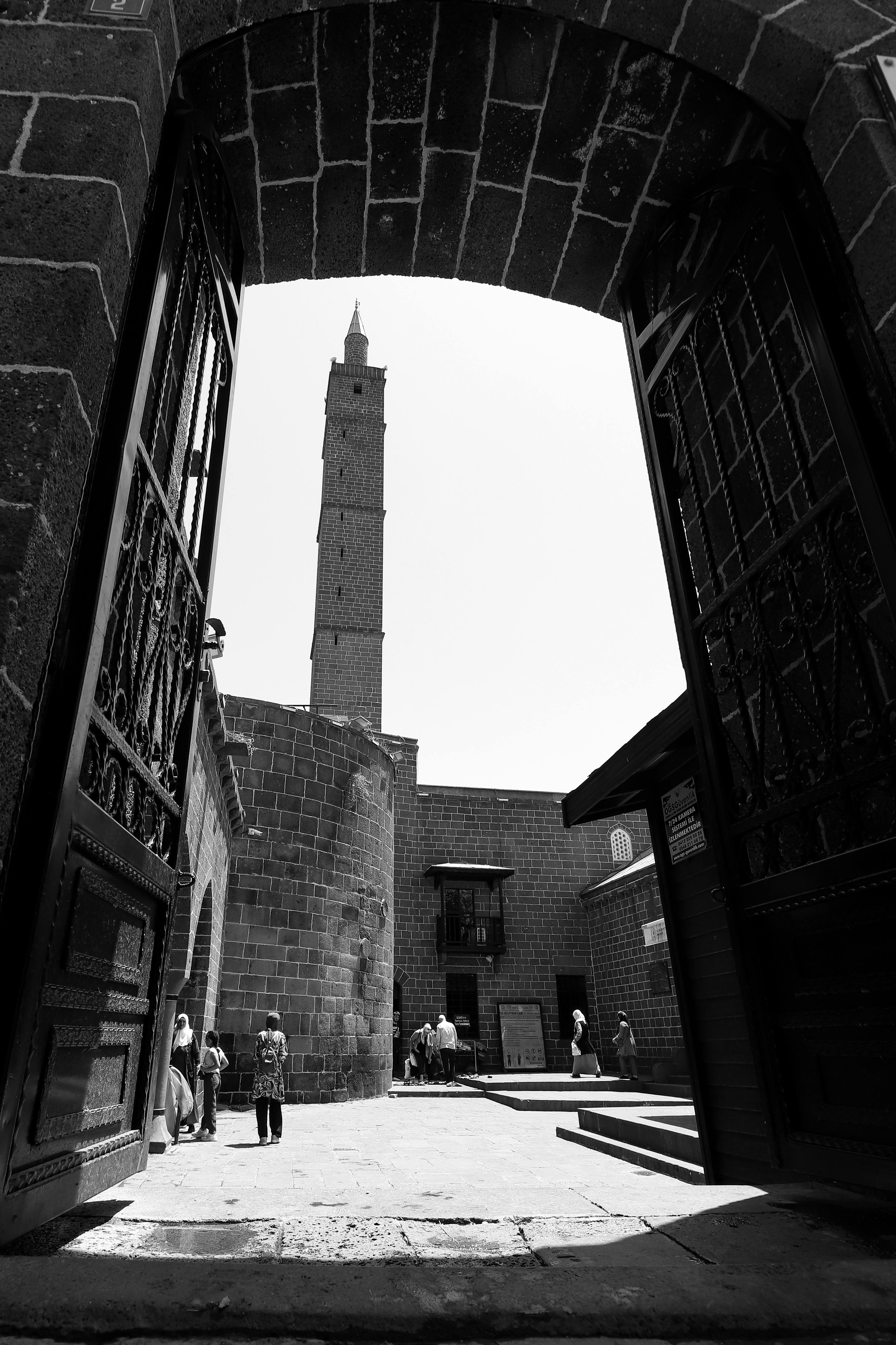 A captivating view of Gothic architecture with a tower and courtyard in a city setting.