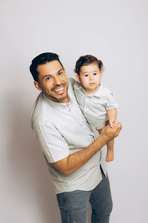 Free A joyful father holding his young son in a bright indoor setting. Captures family love and togetherness. Stock Photo