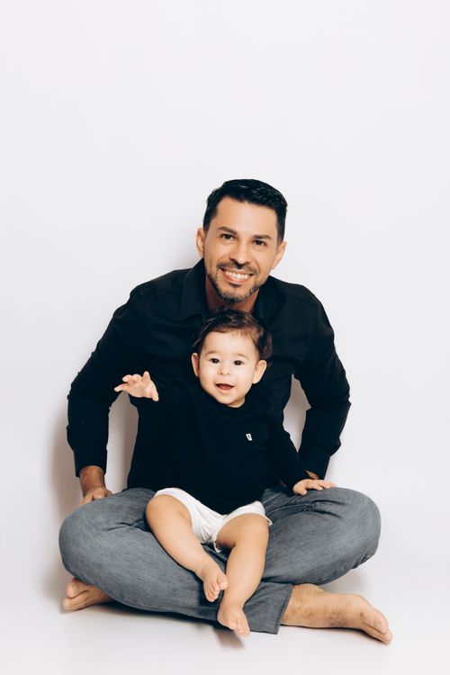 Free Father and young son sitting together, smiling joyfully, showcasing family warmth and affection. Stock Photo