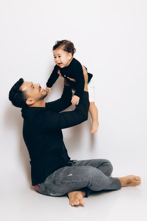 Free A joyful moment between father and son in a modern studio with a bright background. Stock Photo