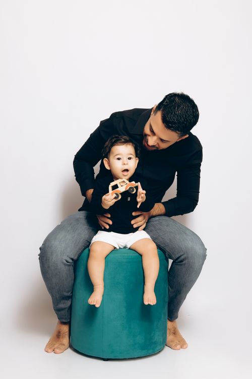 Free Heartwarming portrait of a father and son sharing a playful moment indoors, sitting together. Stock Photo
