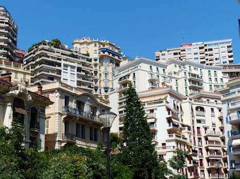 A scenic view of Monaco's luxurious residential architecture under a clear blue sky. by Pixabay