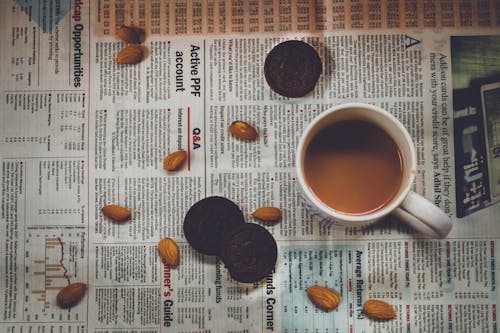 White Ceramic Mug on Newspaper