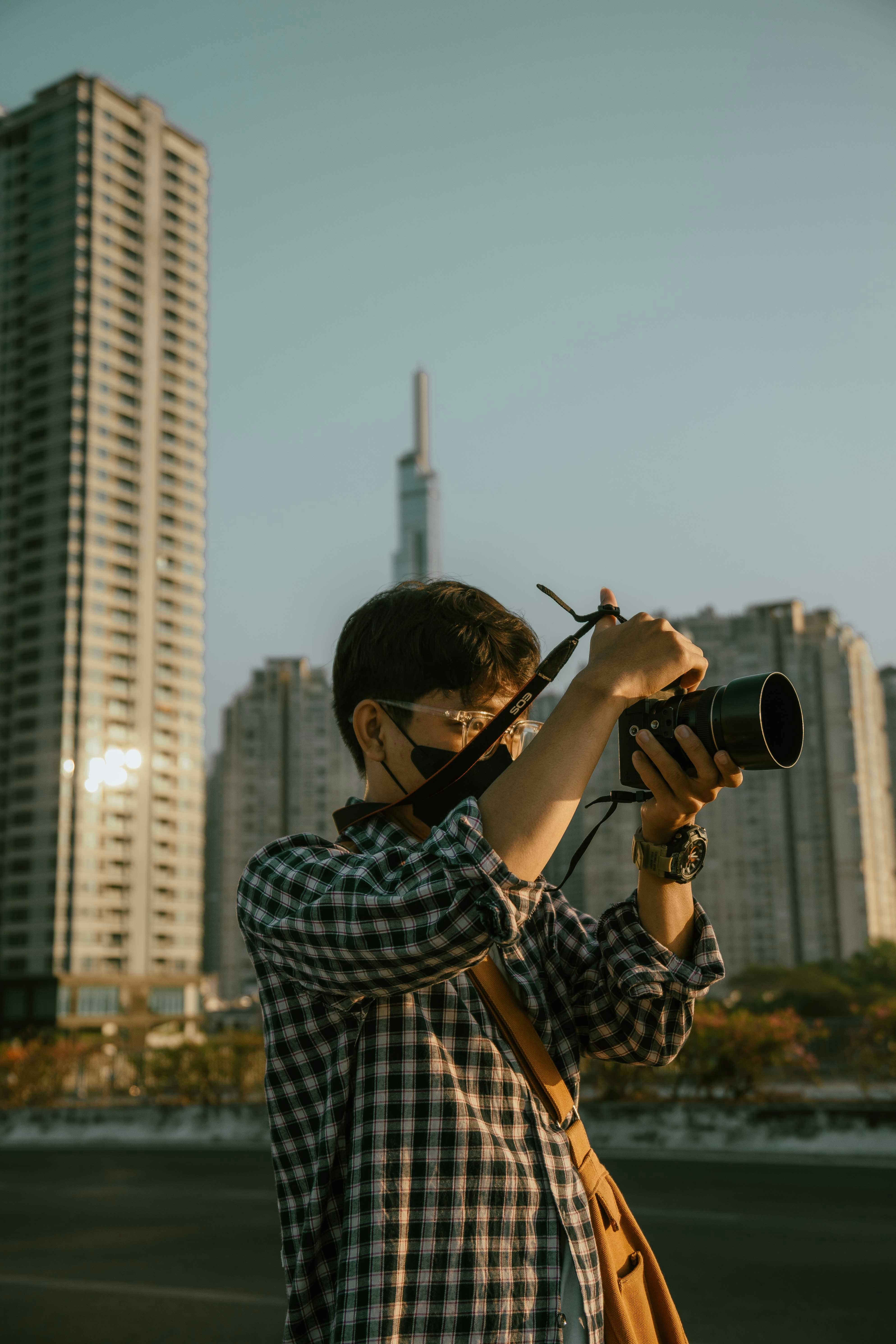 Man with camera photographing the skyline in Ho Chi Minh City during sunset.