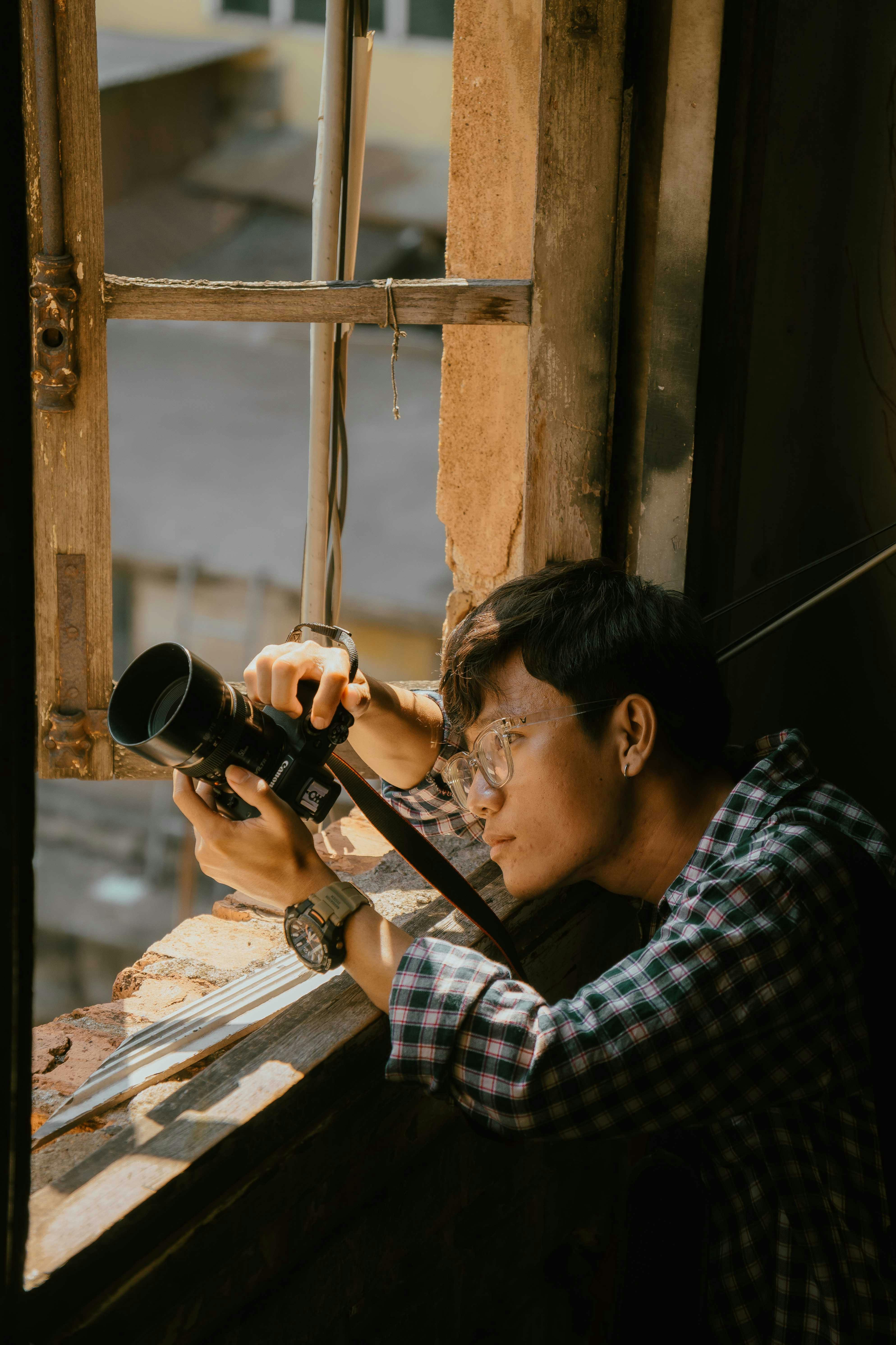 a man taking a photo from a window