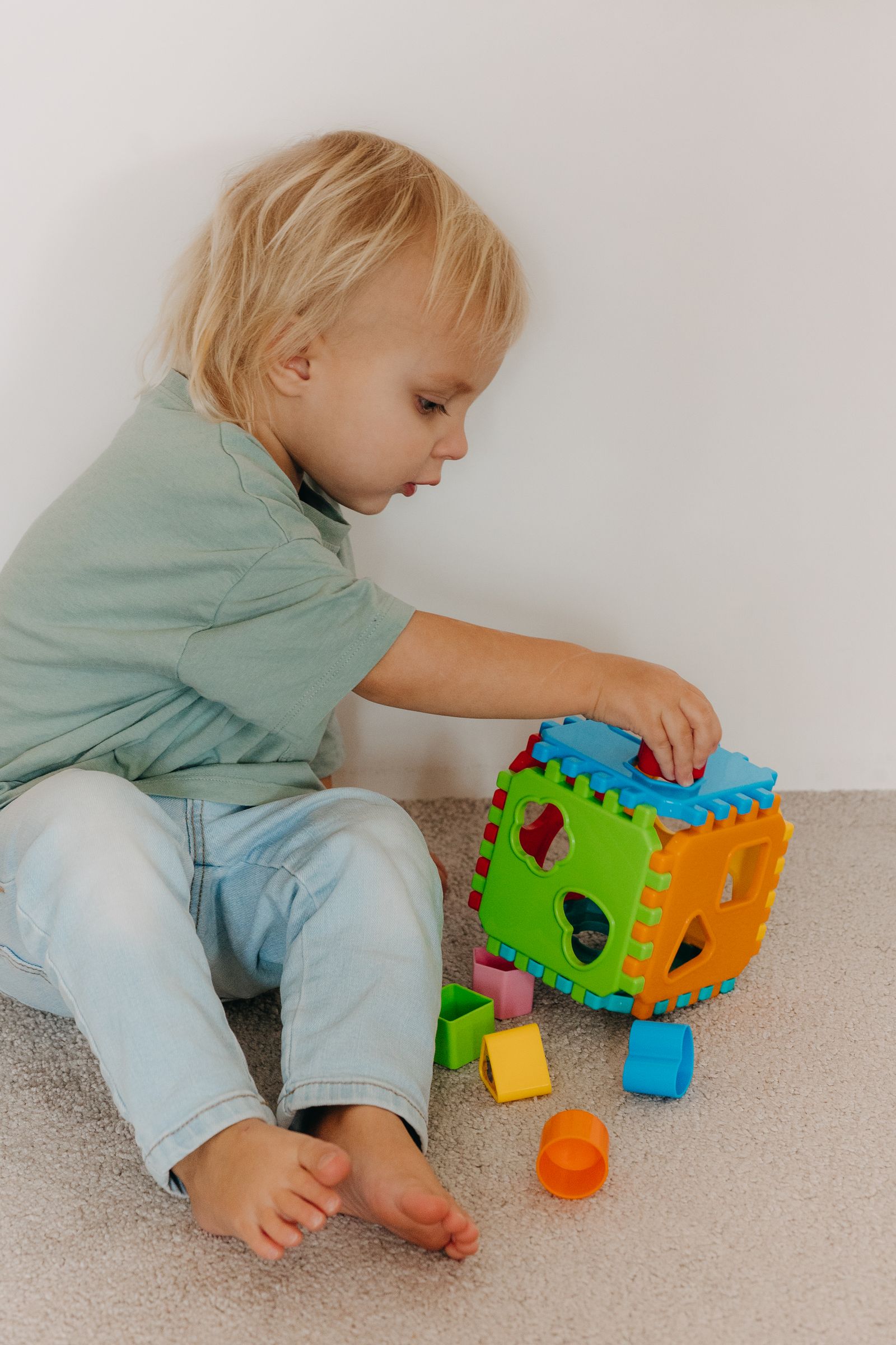 Young child exploring a colorful educational shape-sorting toy