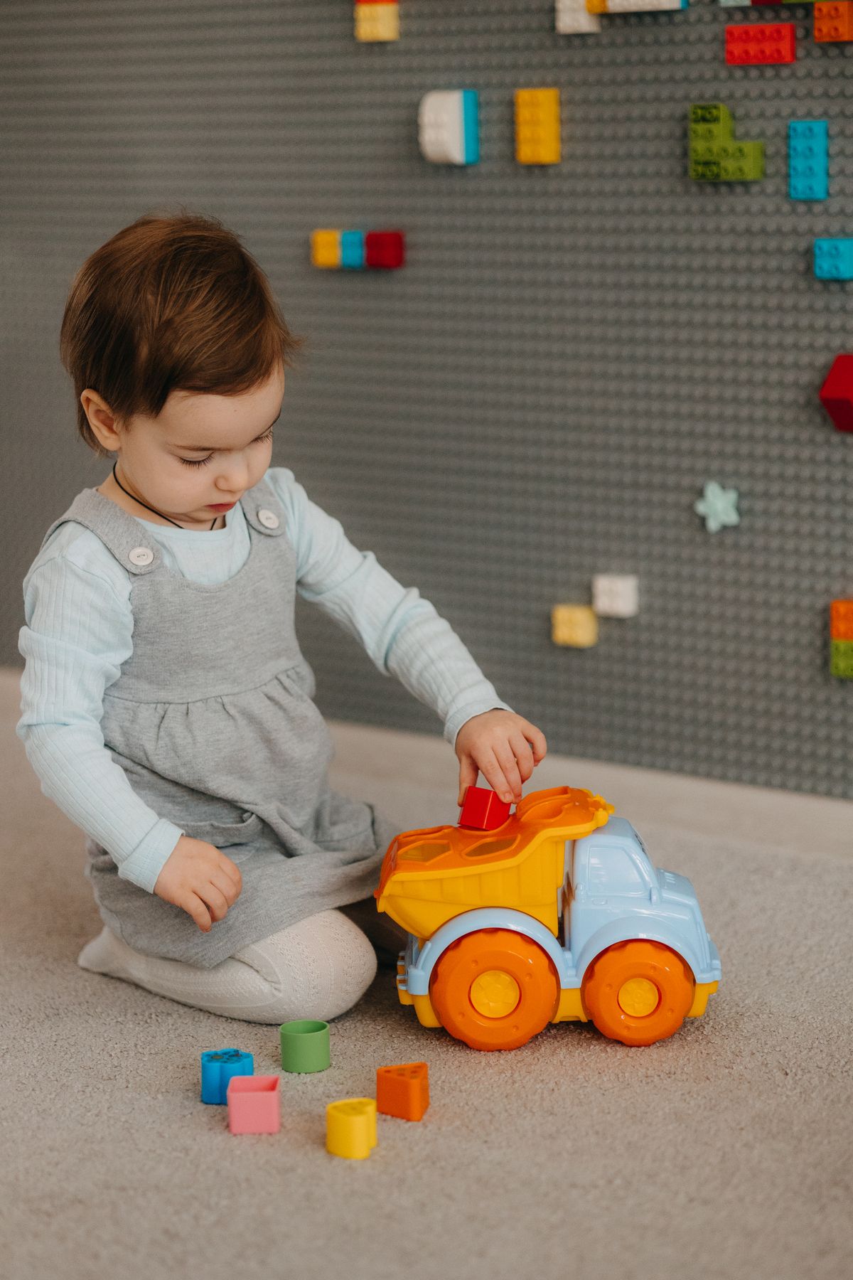 Child in White Long-sleeve Top and Dungaree Trousers Playing With Lego ...