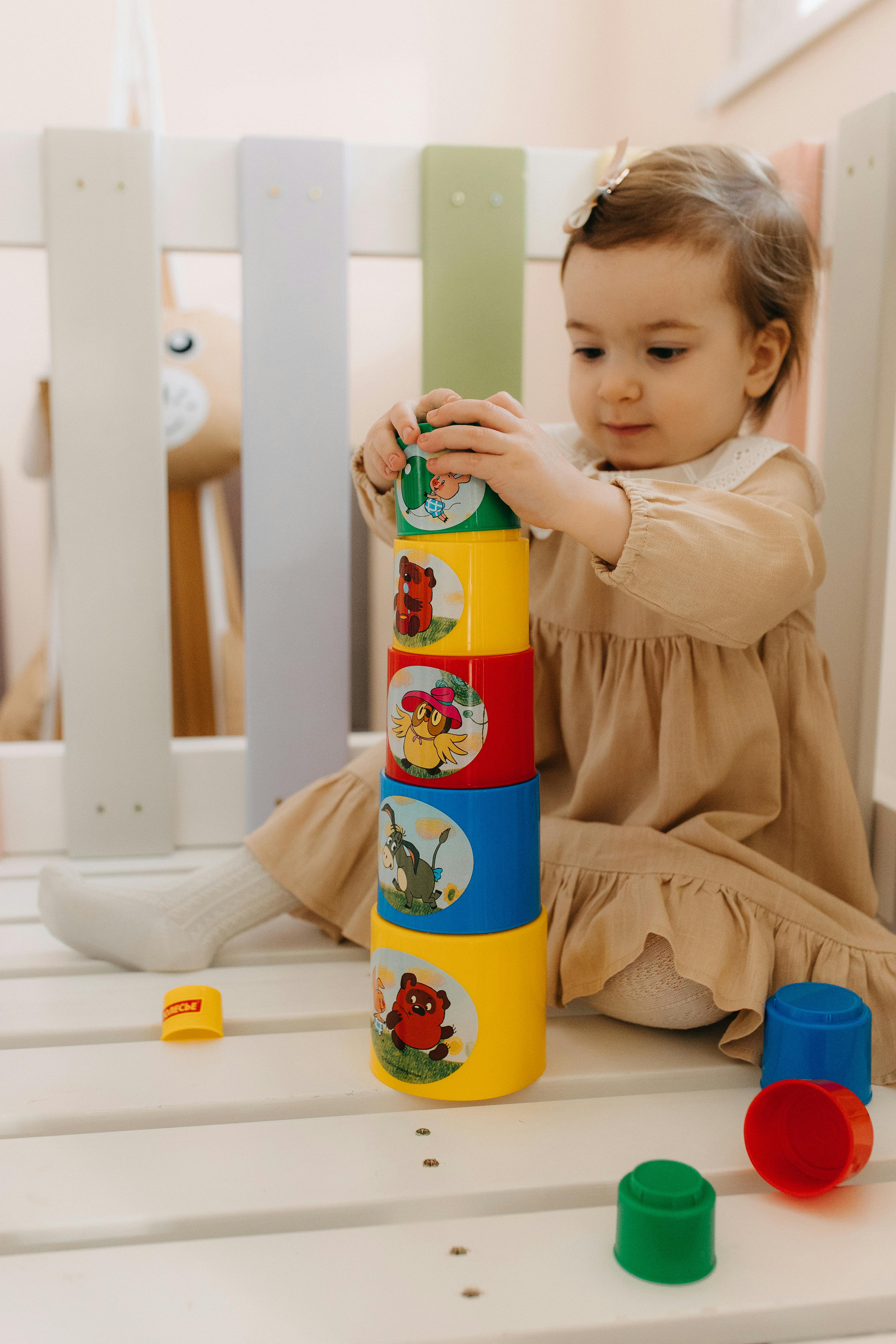 a baby playing with a toy tower in a crib