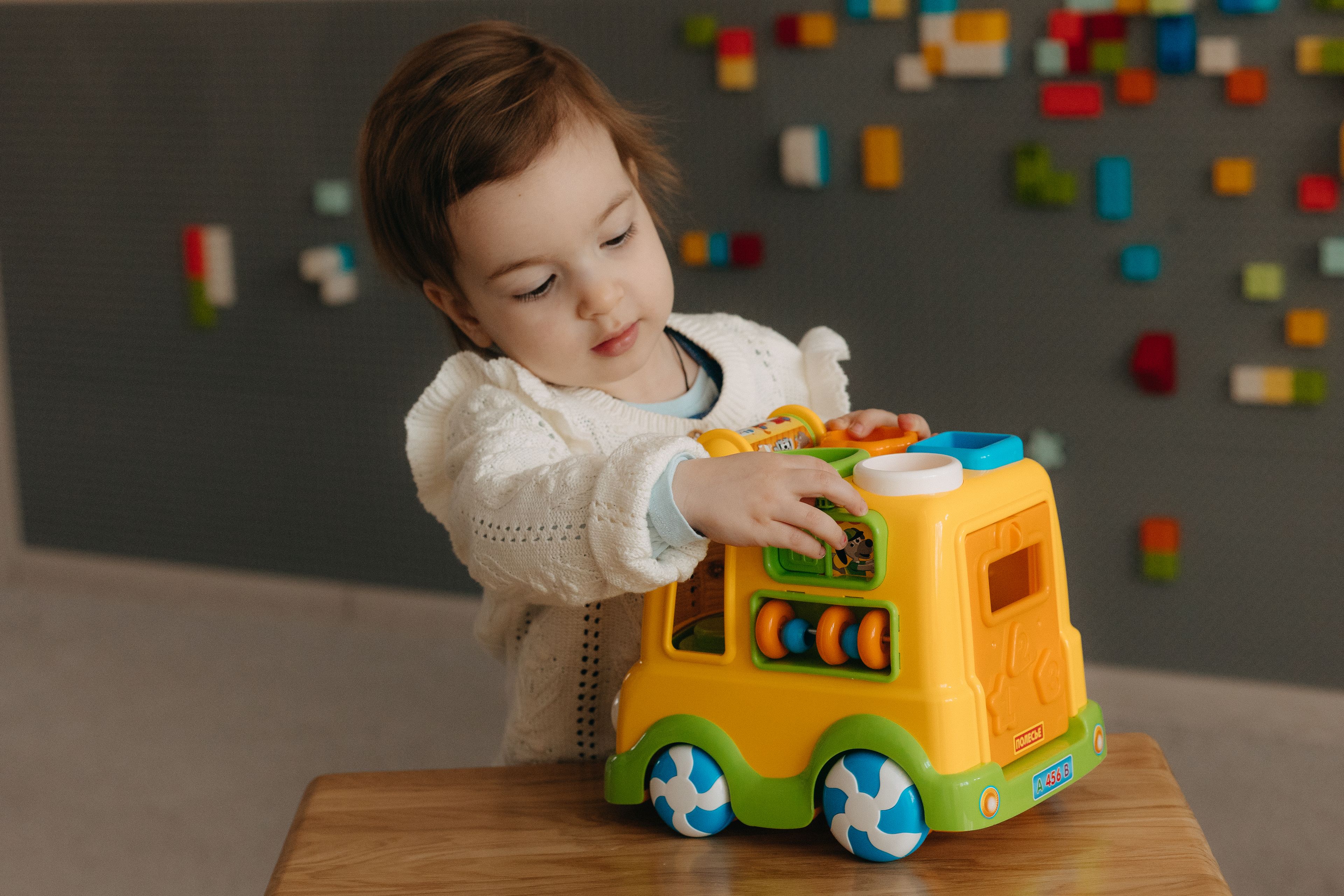 A toddler playing with a toy truck