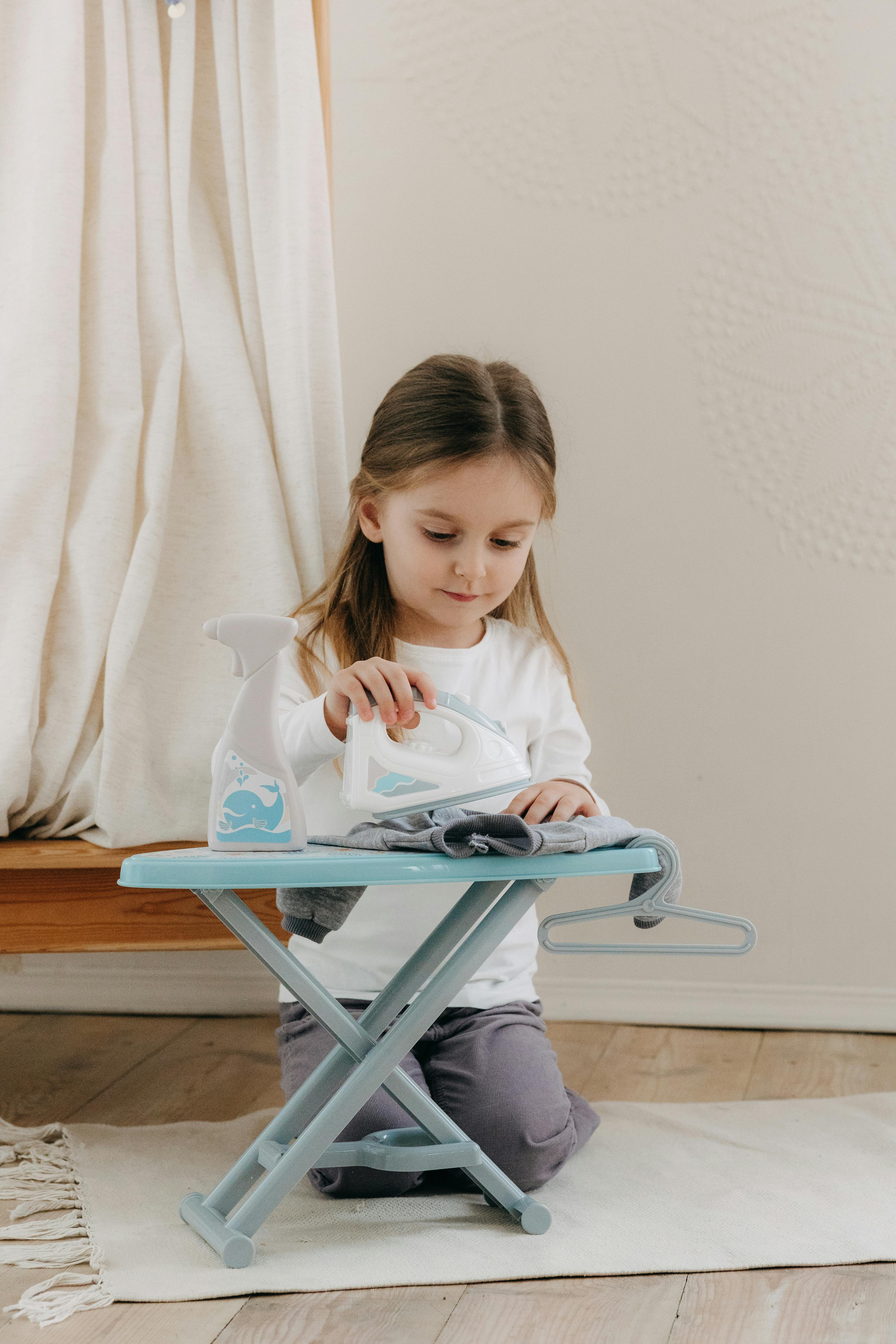 a little girl sitting on a blue folding chair