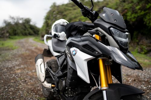 Free Dynamic shot of a BMW motorcycle positioned on a gravel path outdoors, perfect for adventure enthusiasts. Stock Photo