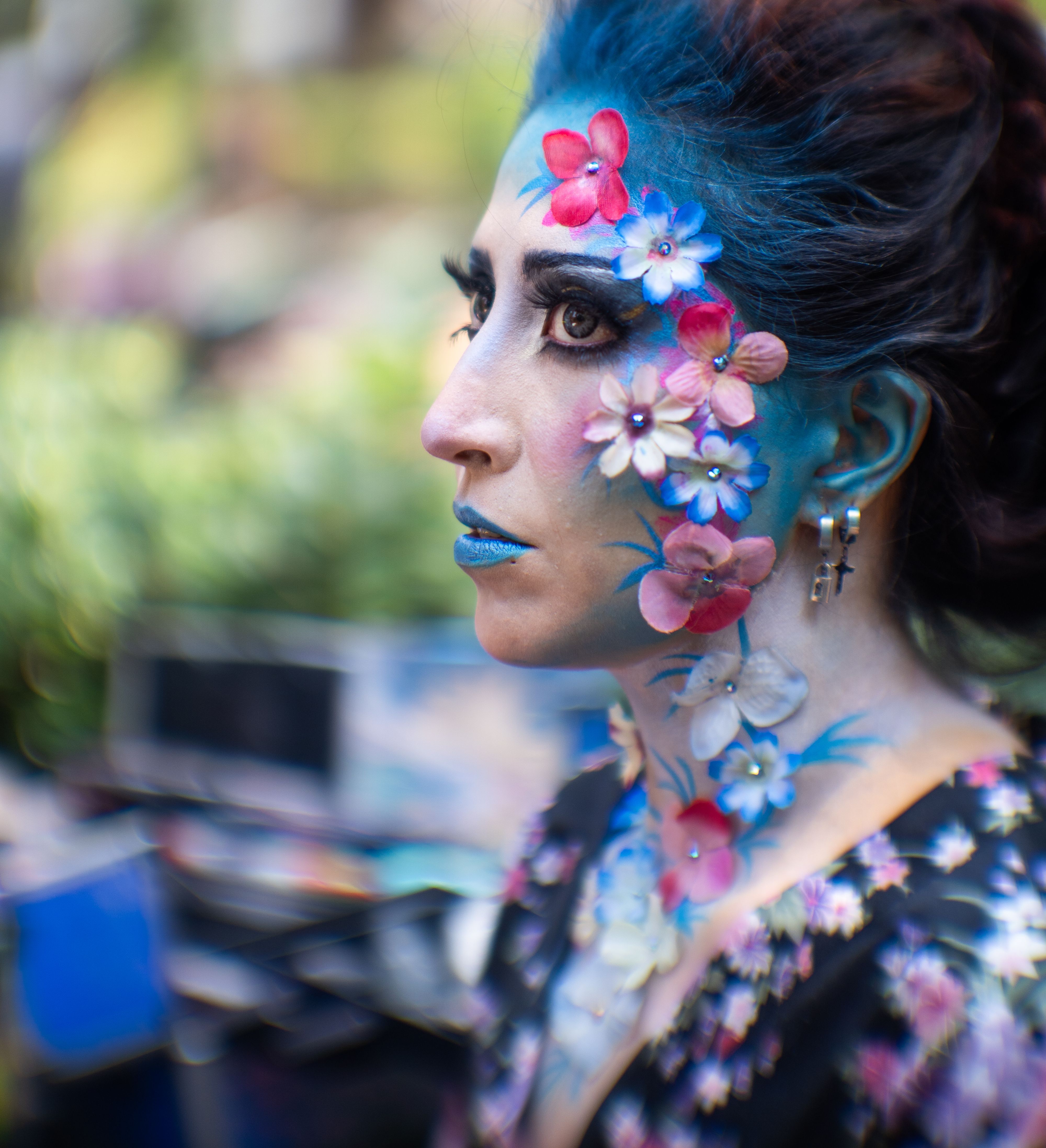 A woman with blue and pink face paint and flowers on her face · Free ...