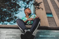 一个时尚的男人在日光下的城市建筑前自信地摆姿势