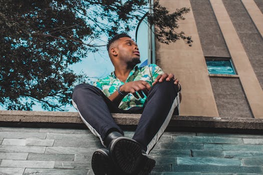 一个时尚的男人在日光下的城市建筑前自信地摆姿势