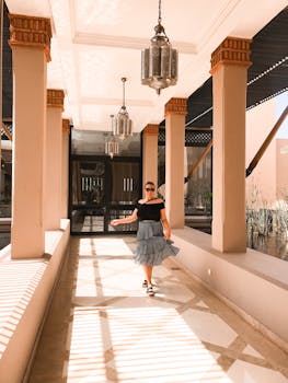 一位穿着时髦的女人走过挂着灯笼的现代建筑走廊