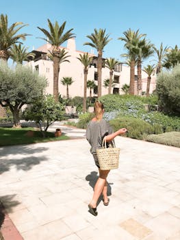 阳光明媚的日子里，一个女人走过郁郁葱葱的热带度假花园，捕捉着放松与宁静