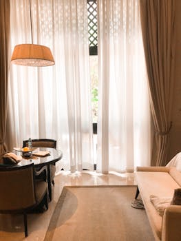 Cozy modern interior with sofa, table, and large window providing natural light.