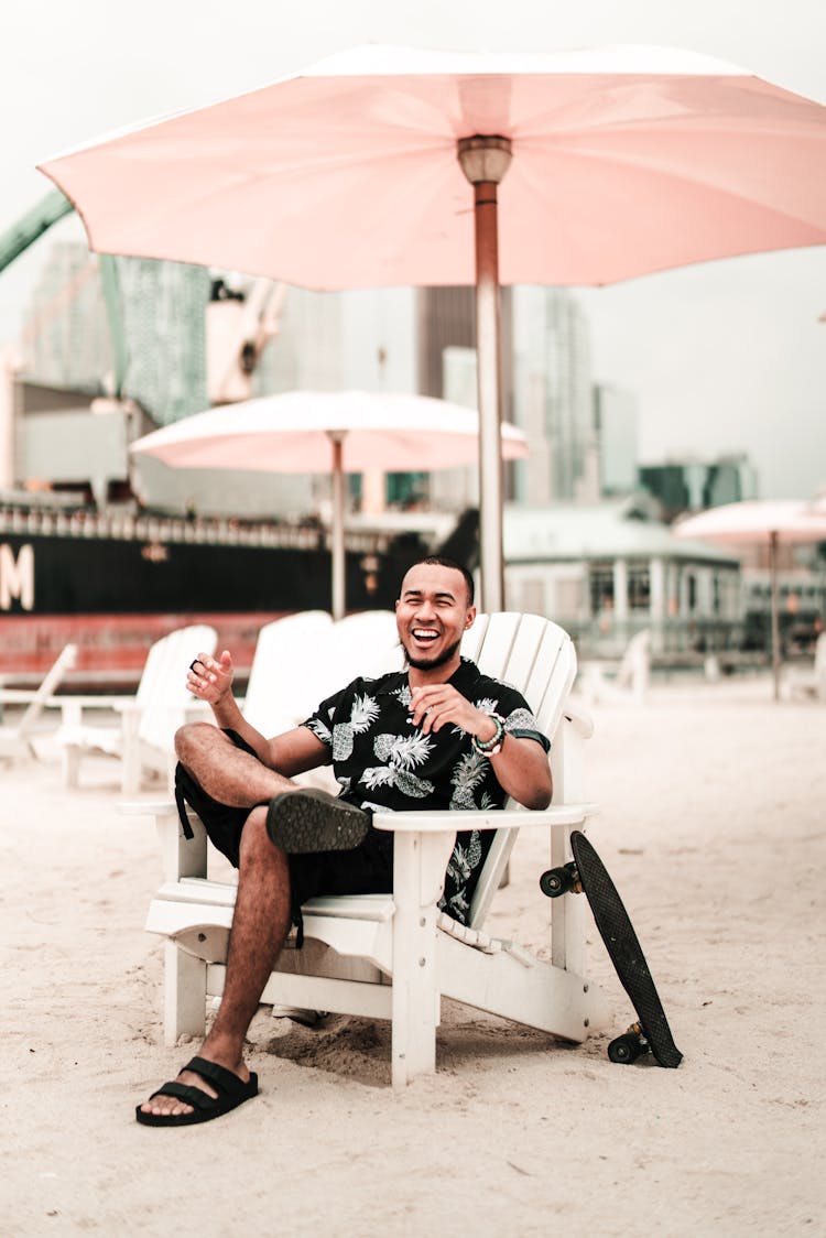 Man Sitting Under A Beach Umbrella