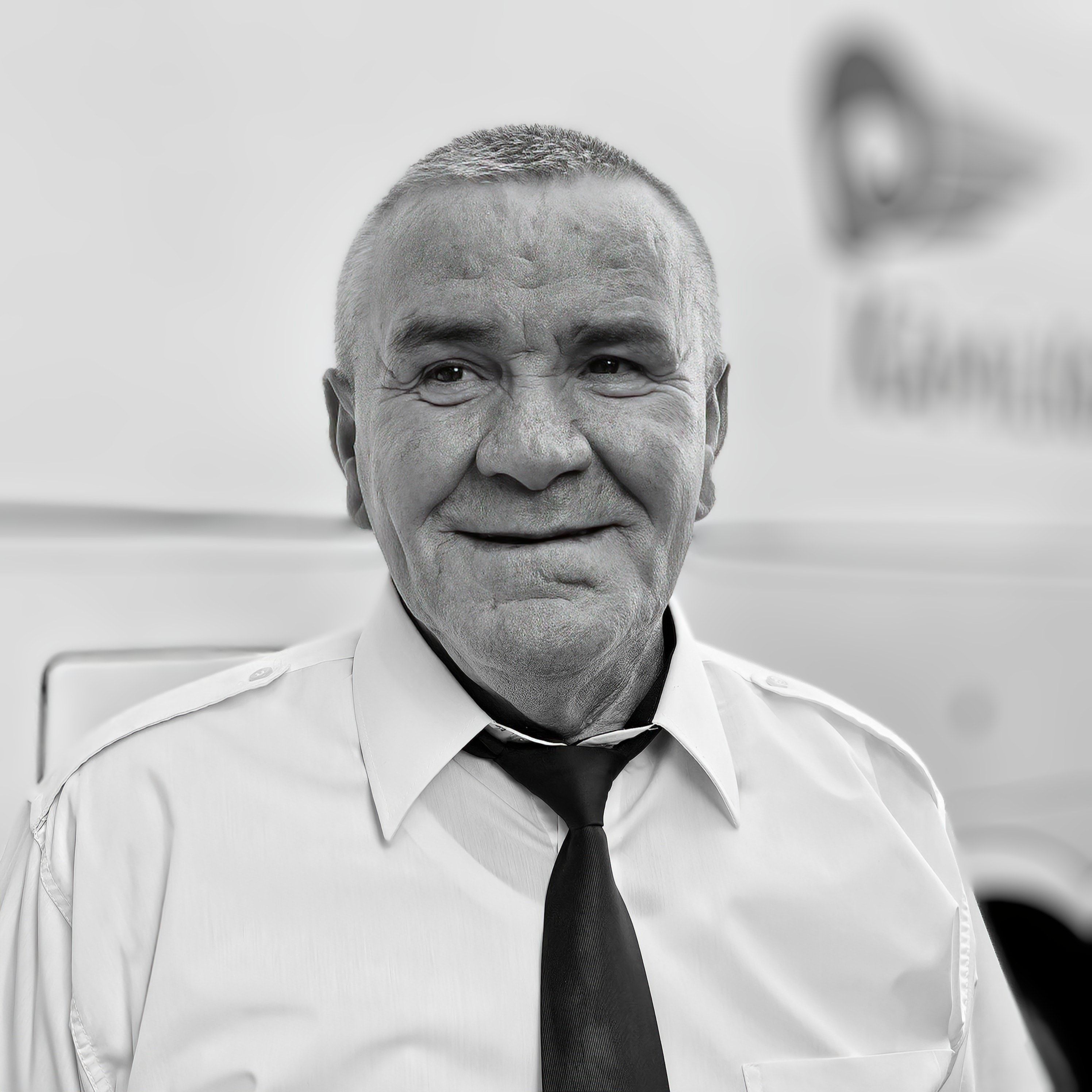 A man in a tie and shirt smiling