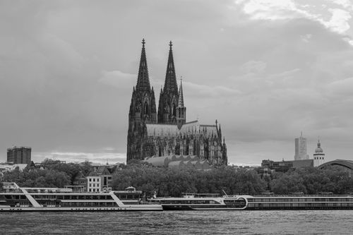 Free Stunning black and white view of Cologne Cathedral across Rhine River, showcasing Gothic architecture and vibrant cityscape. Stock Photo