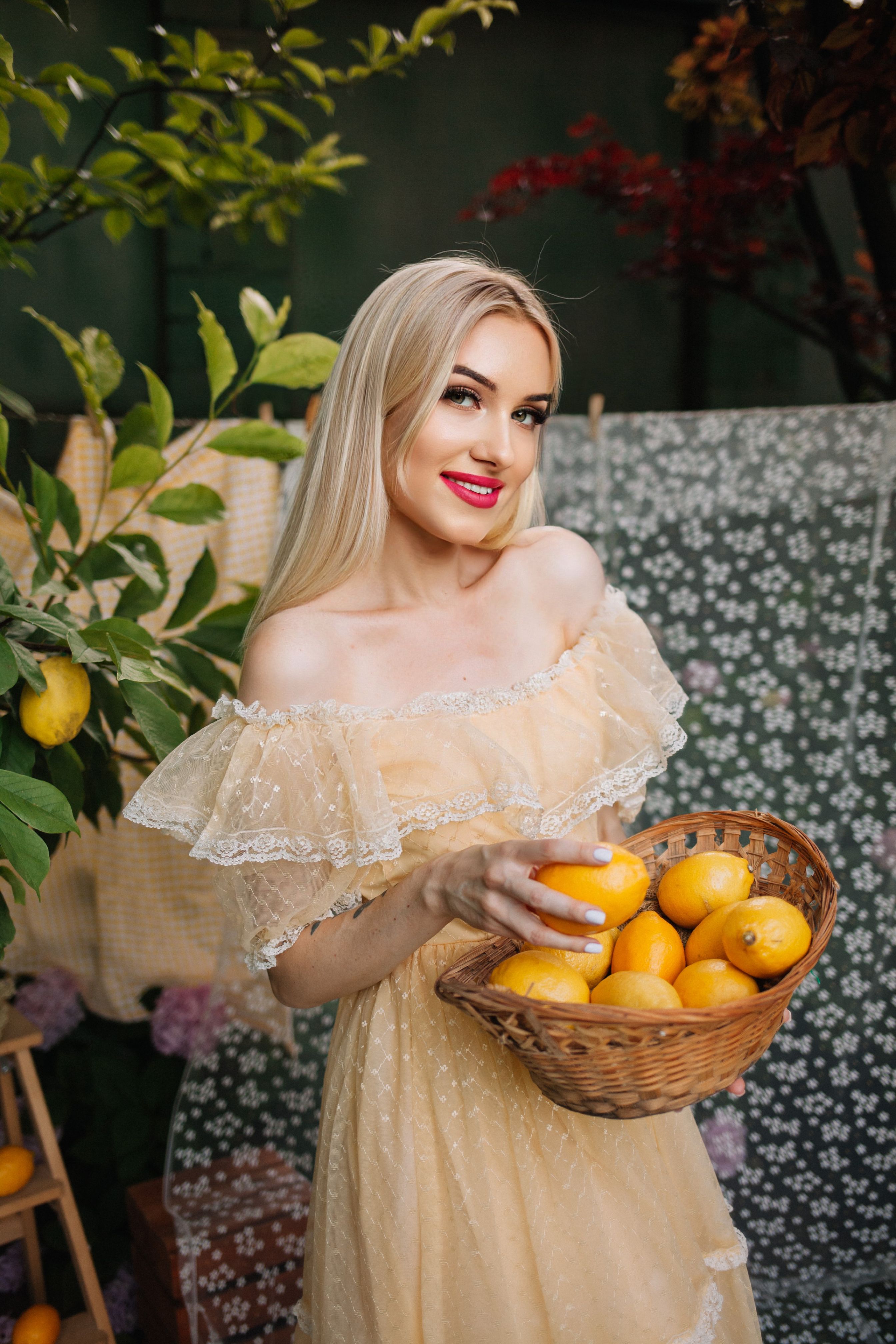 A woman in a yellow dress holding a basket of lemons · Free Stock Photo