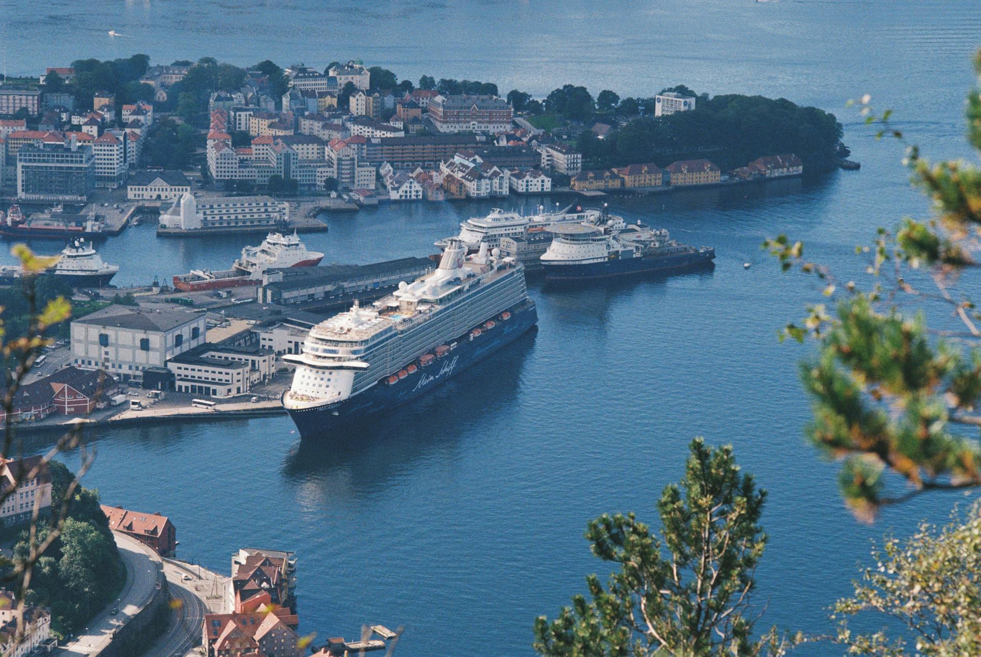 Cruise ships docked at Bergen harbor with a picturesque cityscape in the background.