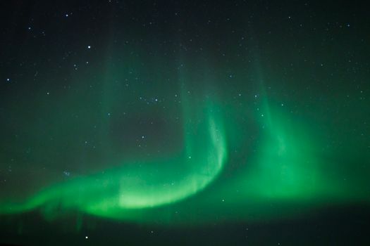 The aurora bore is seen in the sky over the ocean