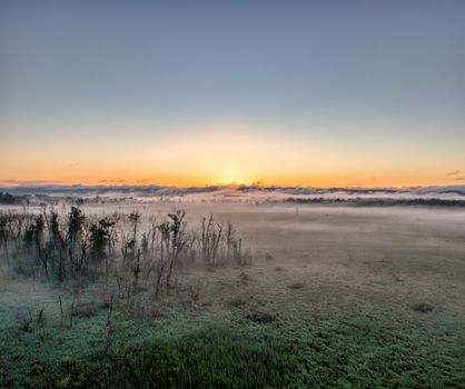 Breathtaking sunrise with mist over fields in Kellogg, MN, creating a serene and peaceful scene.