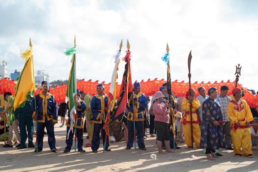 Colorful street festival with traditional costumes and flags in Vũng Tàu, Vietnam.