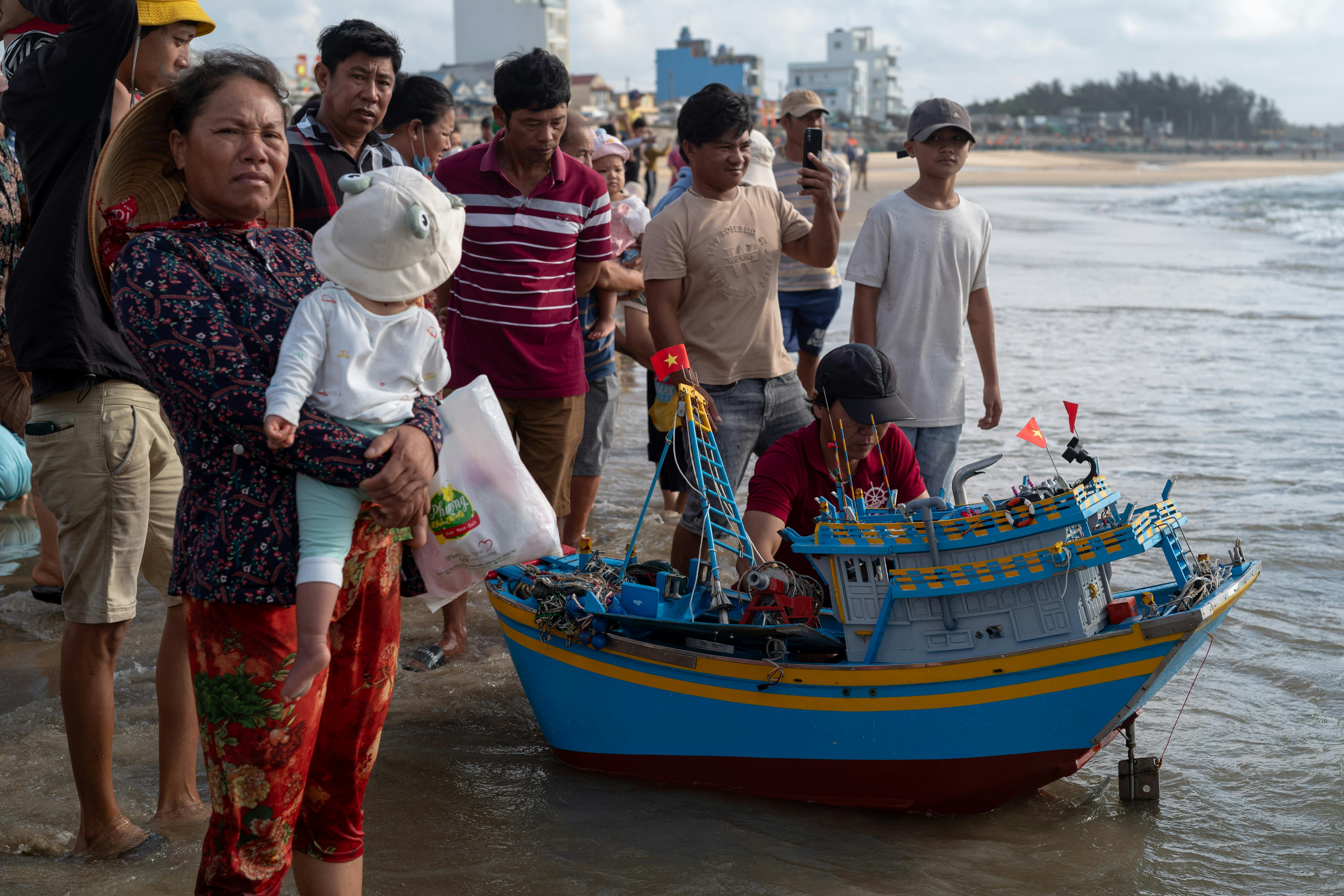 A lively beach scene with a crowd enjoying a colorful display in Vũng Tàu, Vietnam.