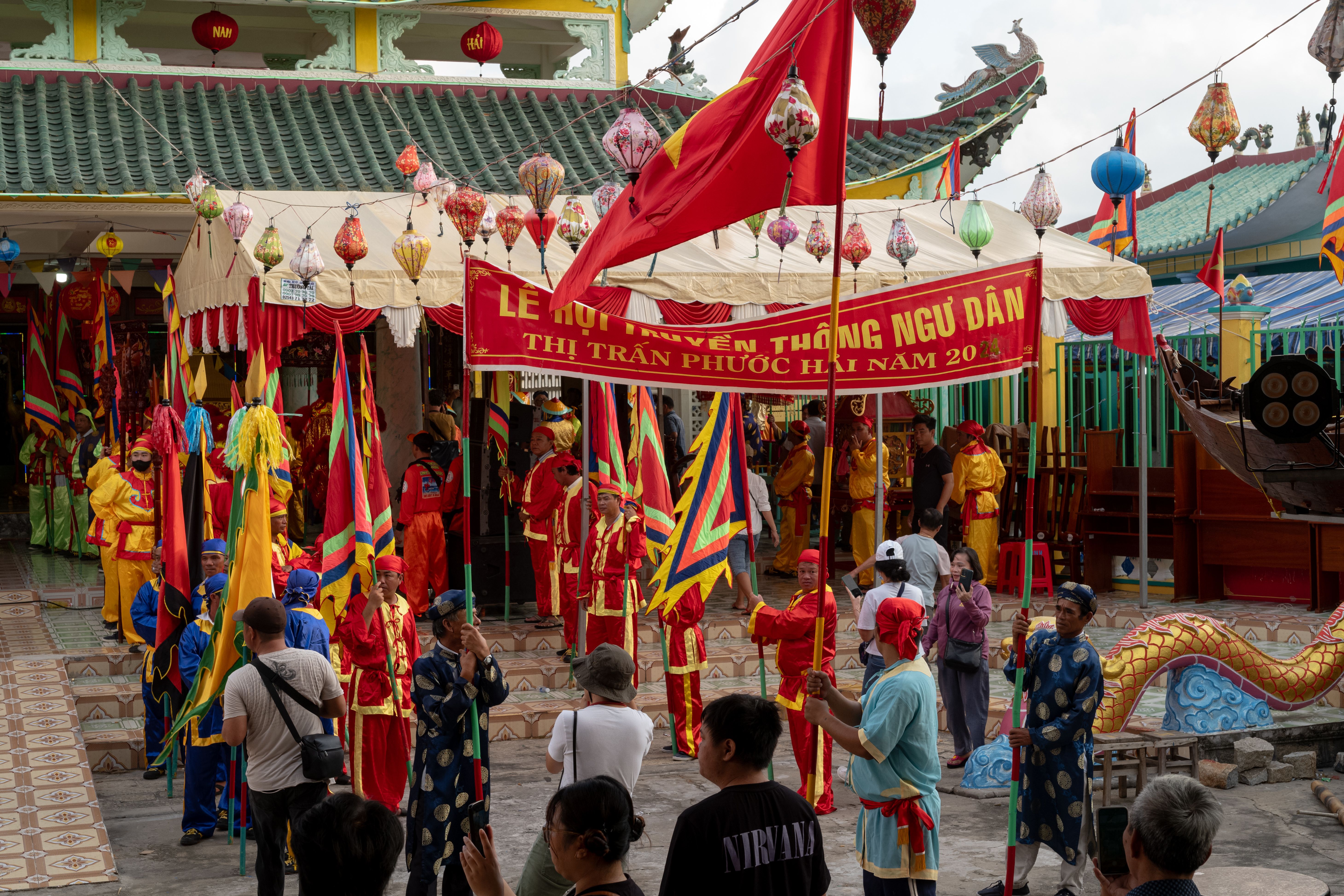 Vibrant traditional parade in Vũng Tàu featuring colorful flags and costumes