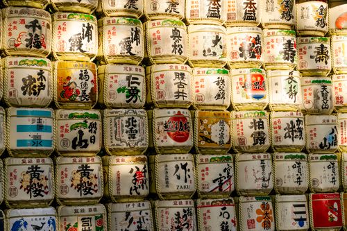 Free Sake barrels on display at a Tokyo shrine showcasing Japanese calligraphy and culture. Stock Photo