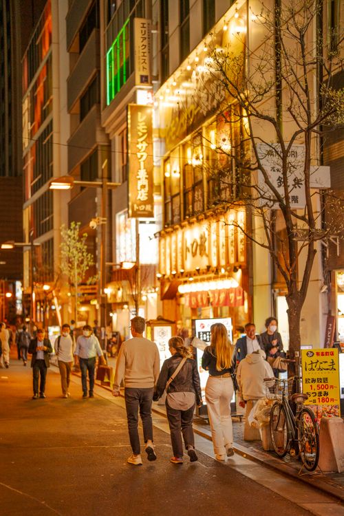 Free A bustling street scene in Japan at night, showcasing illuminated shops and pedestrians enjoying the vibrant nightlife. Stock Photo