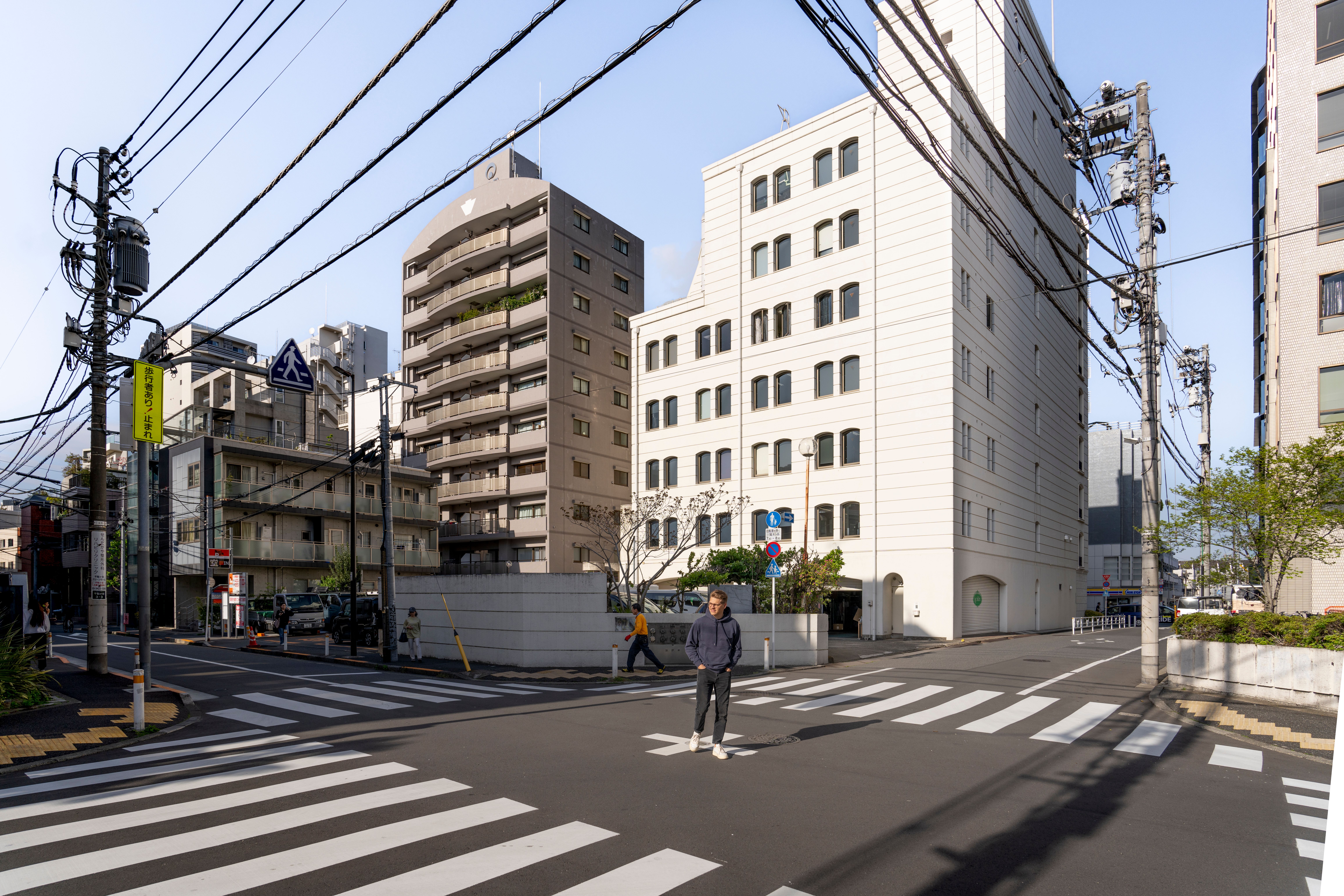 A person is crossing the street in front of tall buildings · Free Stock ...