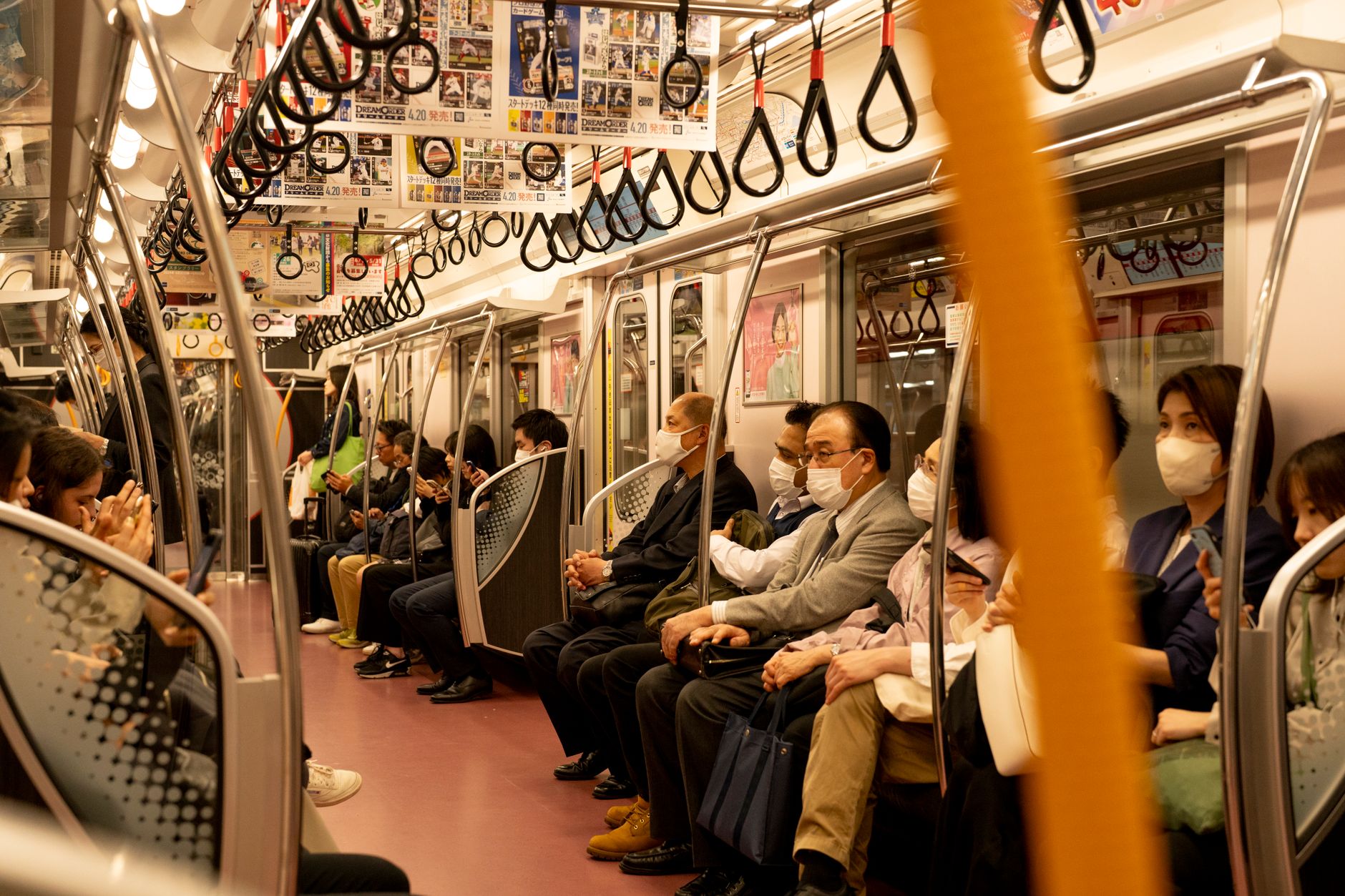일본 아오모리현 지진 발생 8 Masked commuters sitting in a Tokyo subway train showcasing urban travel and safety.