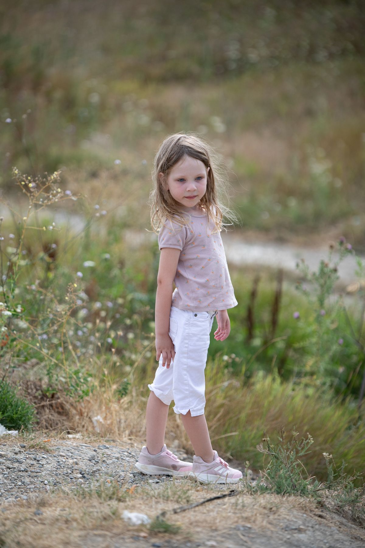 A little girl sitting on the rocks in a dress · Free Stock Photo