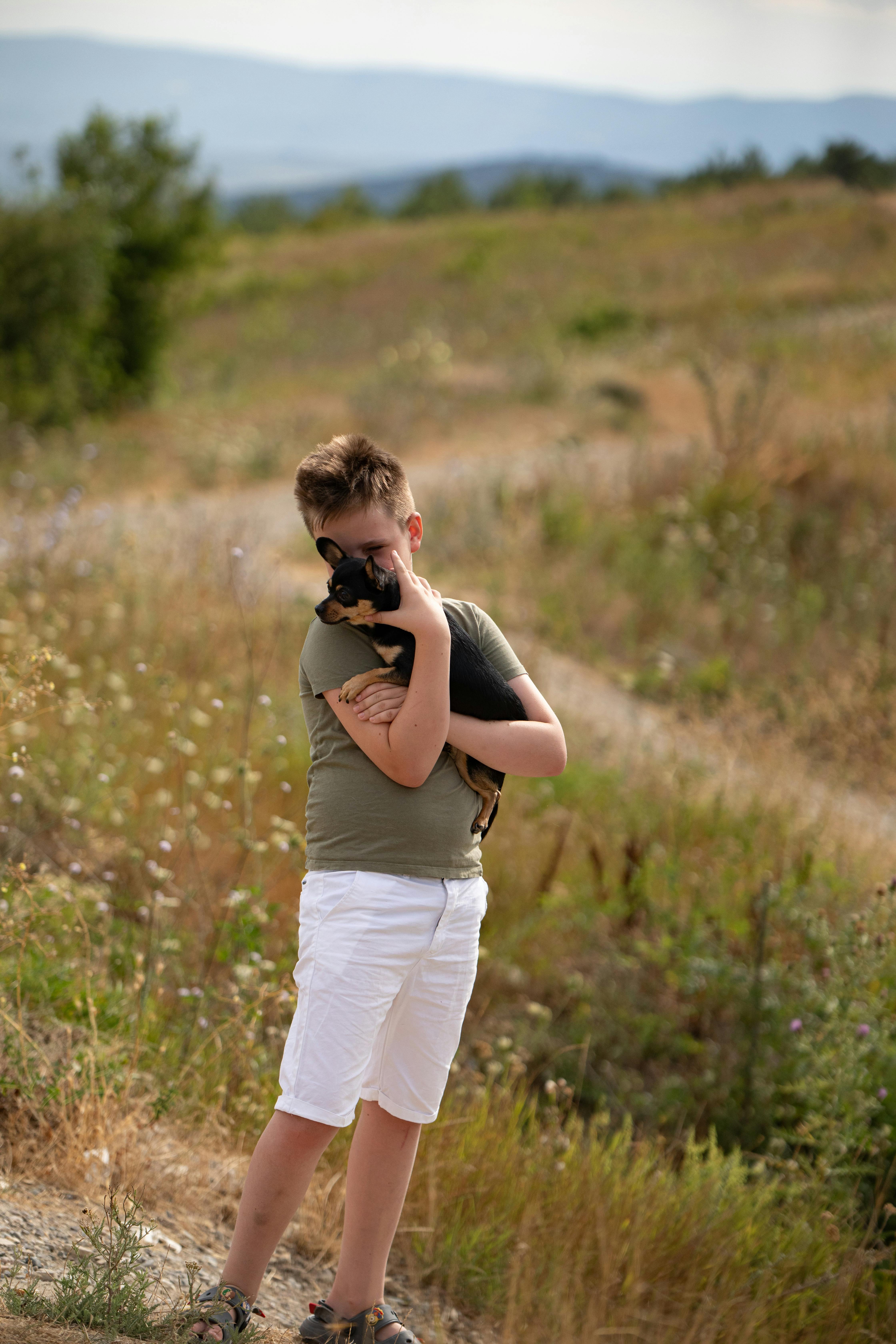A boy holding a dog in his hand