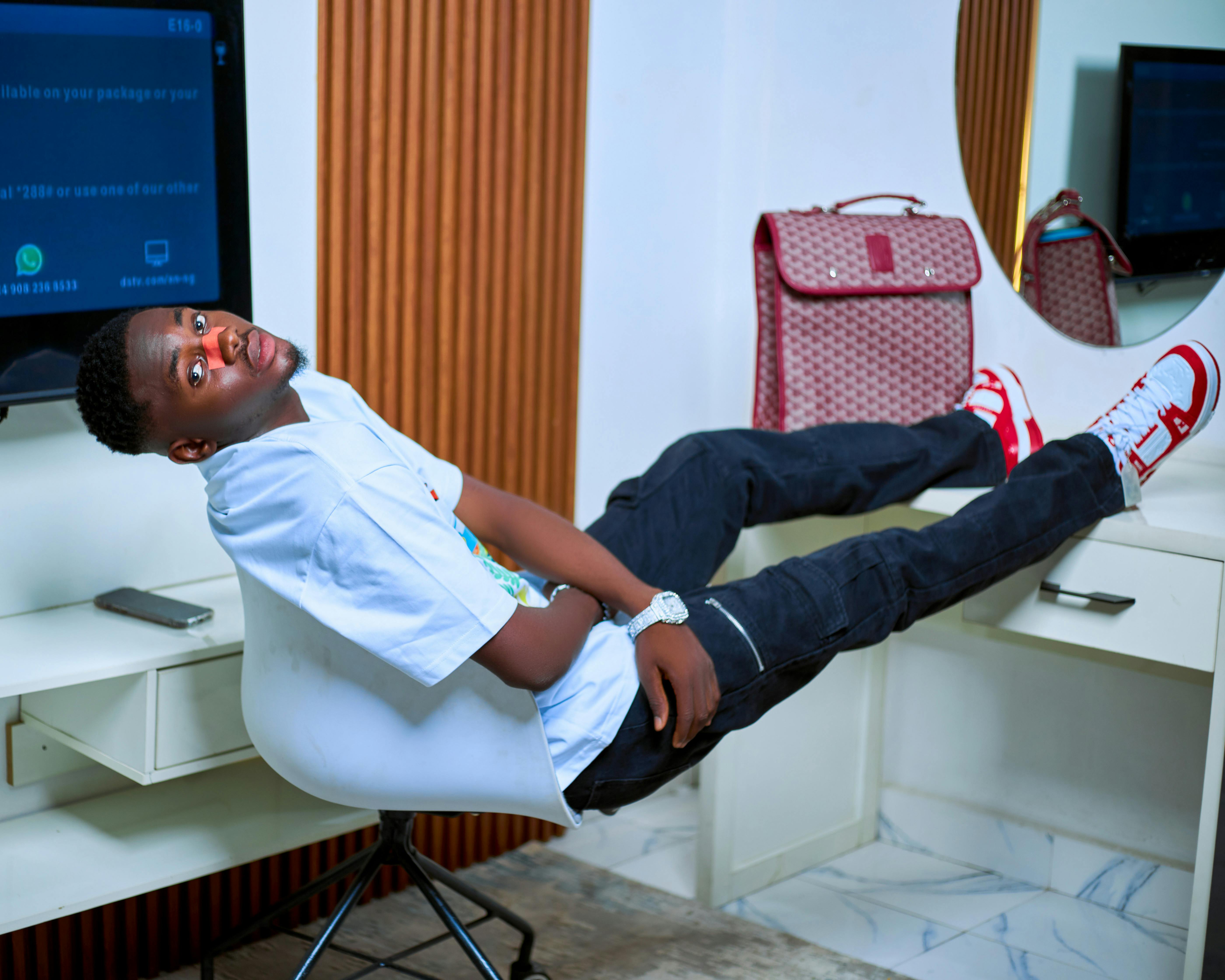 a man laying on his back in a chair with a laptop