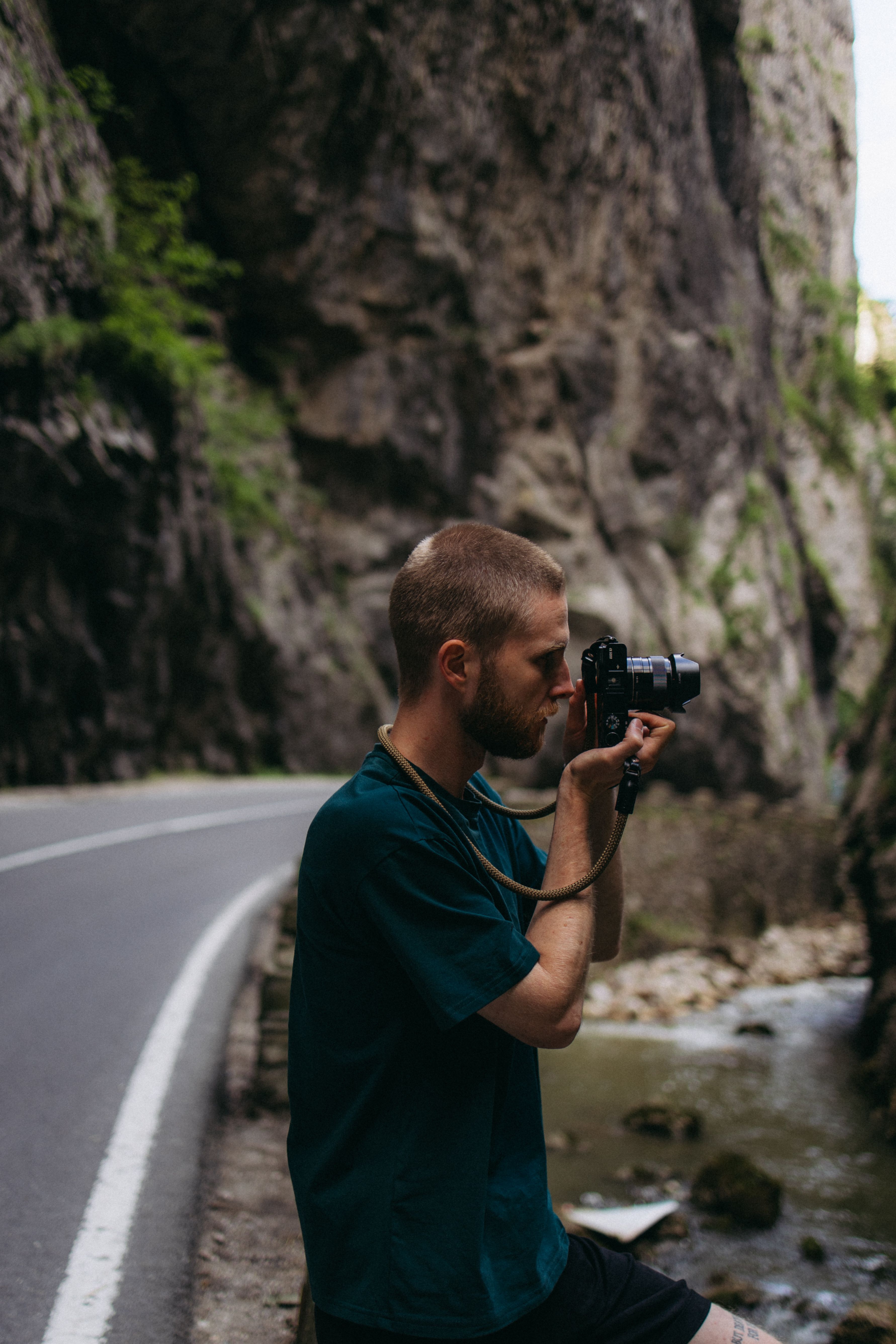 Man capturing Romania's Bicaz Gorge with a camera, showcasing the natural beauty and adventure.