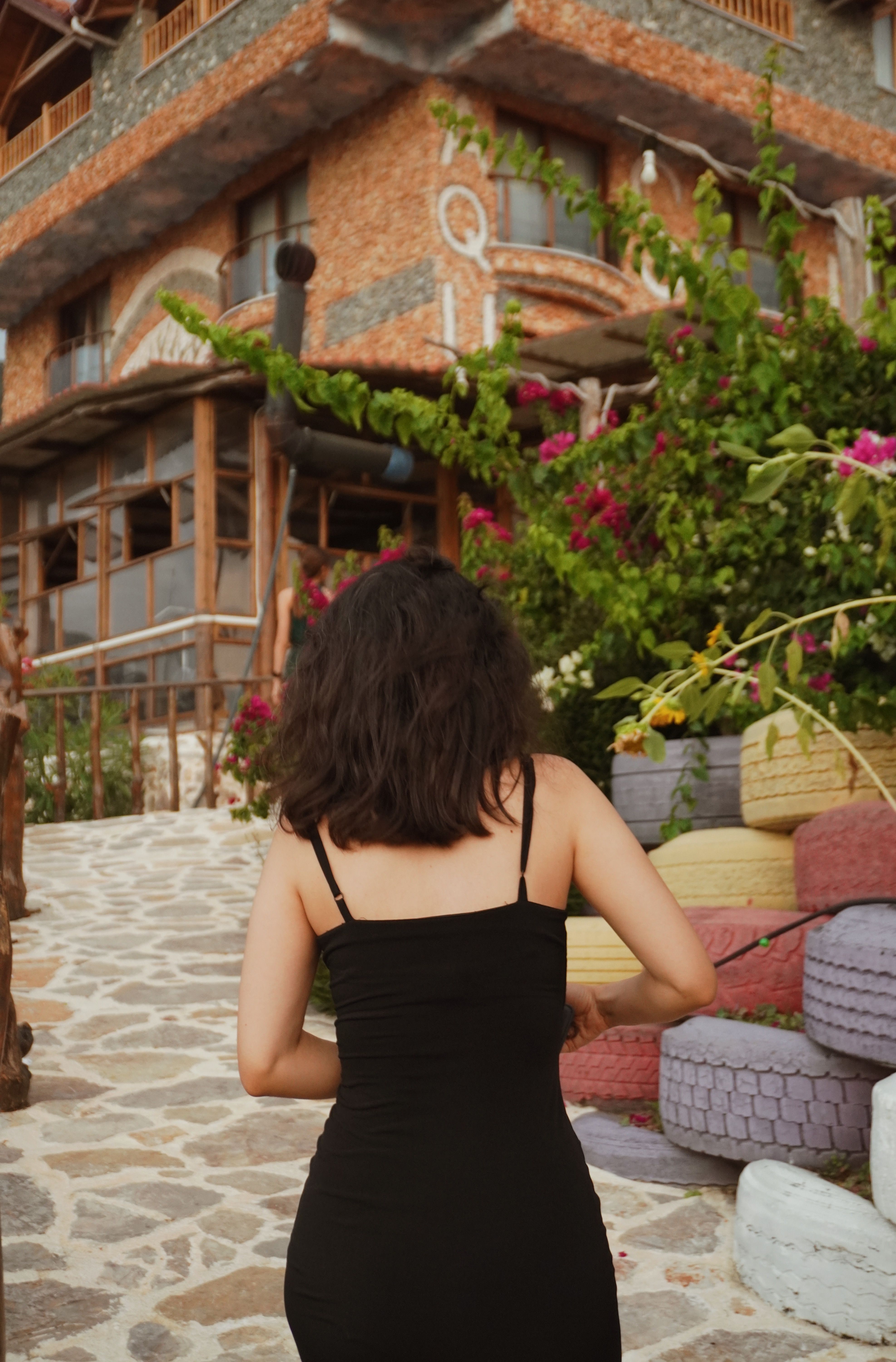A woman in a black dress walking down a path · Free Stock Photo