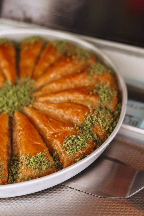 Free Close-up of freshly baked baklava with pistachio garnish, showcasing vibrant colors and traditional dessert art. Stock Photo